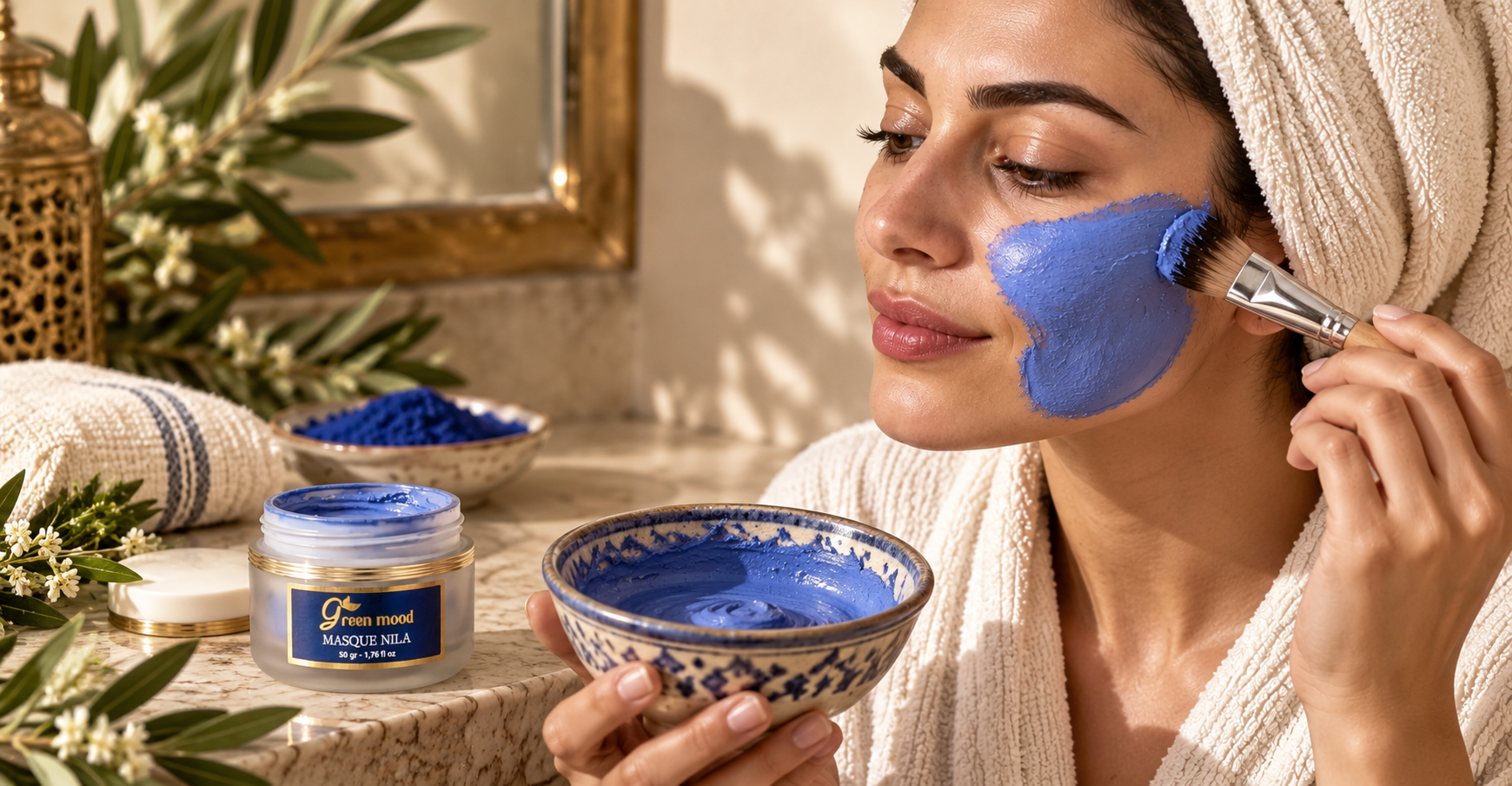 Application du Masque Nila Royal Green Mood en couche fine sur la joue, avec un pinceau plat